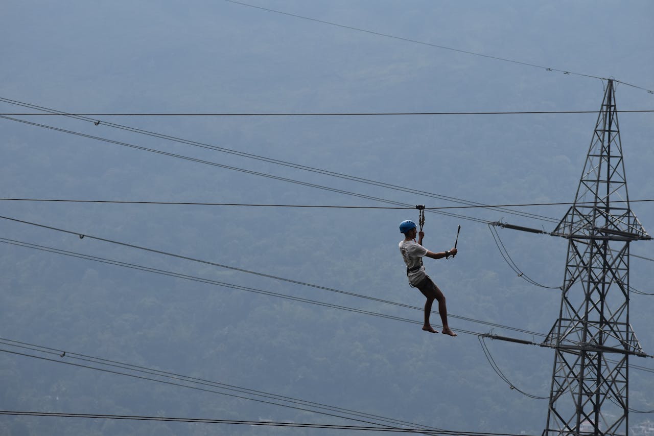 services-01 High-altitude worker inspects power lines, emphasizing safety and risk in industrial work.